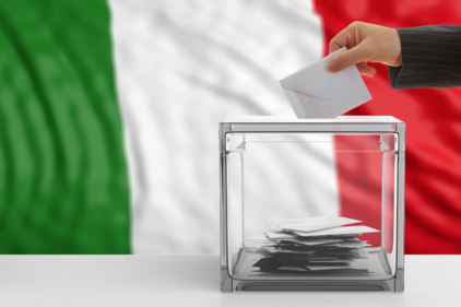 Gläserne Wahlurne, männliche Hand wirft Stimmzettel ein, italienische Flagge im Hintergrund  Flagge   